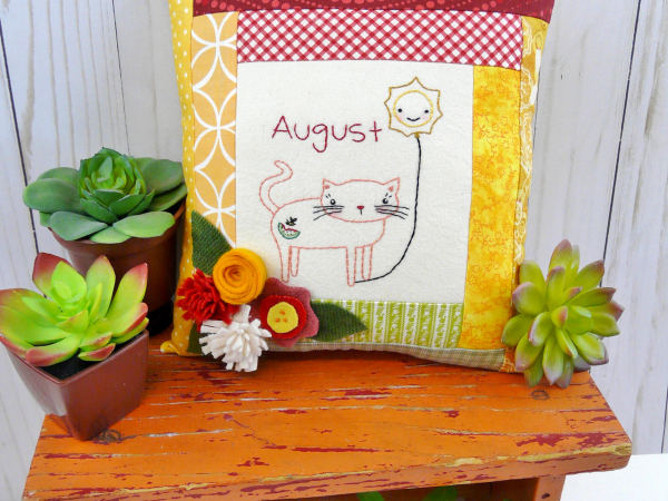 kitty cat holding the month of august hot balloon wool flowers